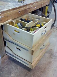 a workbench with two drawers and tools in it's bottom drawer that is open