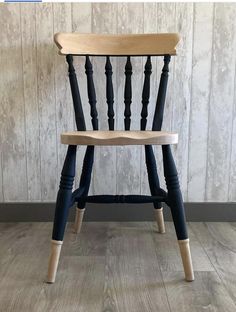 a wooden chair sitting on top of a hard wood floor next to a white wall