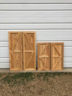 three wooden doors sitting next to each other in front of a white garage door on the side of a building