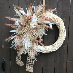 a wreath hanging on the side of a wooden fence