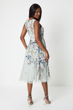 Exquisite hand-embellished floral embroidery adorns this elegant midi dress Flattering V-neckline and sleeveless cut offer a feminine silhouette Crafted from a premium fabric blend for a luxurious drape and feel Defined waistline with a self-tie belt to accentuate your shape Midi length hits below the knee for a refined, occasion-ready look Exude sophistication at your next formal event in this stunning Coast midi dress. The intricate floral embroidery and hand-embellished detailing radiate a sense of luxury, while the sleeveless silhouette and V-neckline offer a timeless, feminine aesthetic. Complement the dress with delicate jewellery and strappy heeled sandals for a polished ensemble befitting weddings, races, or any other special occasion where you wish to make a refined statement. Floral Evening Dresses, Elegant Midi Dress, Delicate Jewellery, Elegant Midi Dresses, Oasis Fashion, Feminine Silhouette, Strappy Sandals Heels, Feminine Aesthetic, Delicate Jewelry