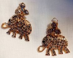 beautiful style and size   Cute rhinestone elephant design Clip on handmade originals  Hangs 2.5 inches medium size Blingy beautiful style Beautiful quality and shine gold metal with blingy crystals  Very lightweight  Classic addition to any wardrobe  Very blingy style Lucky Elephant, Elephant Design, Beautiful Style, Earrings Gold, Clip On, Clip On Earrings, Medium Size, Gold Earrings, Gold Metal