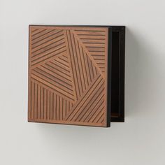 a wooden box that is on the wall with some sort of design in front of it