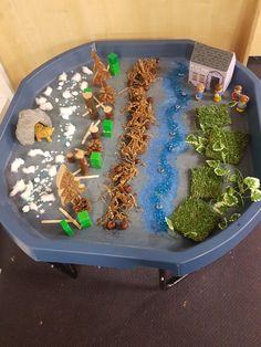 a blue tray filled with toys and water