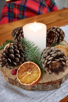 pine cones and orange slices are arranged around a candle