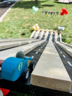 a toy car driving down a wooden track