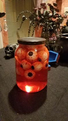 a jar filled with red liquid sitting on top of a table