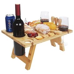 a wooden picnic table with wine and snacks