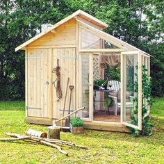 a small wooden shed sitting on top of a lush green field