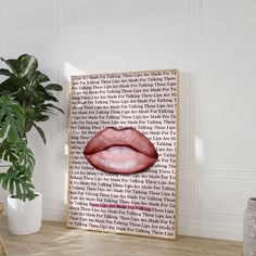 there is a plant in the corner next to a poster with a red lips on it