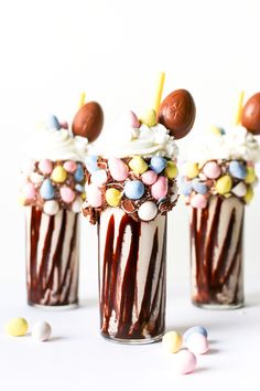 three glasses filled with candy and marshmallows