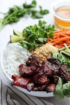 a plate filled with meat and veggies next to dipping sauce