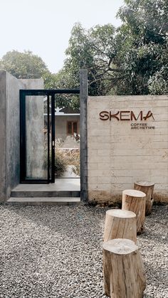 the entrance to skema's modern home is made out of concrete and wood