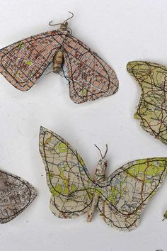 four butterflies made out of maps are shown