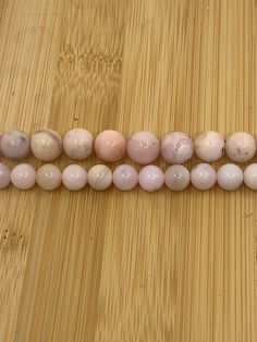 the beads are lined up in rows on the wooden surface, with one bead at the end