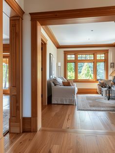 an open living room with wood floors and large windows in the wall to the side