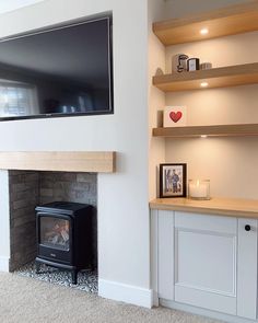 a television mounted on the wall above a fire place in a room with white walls