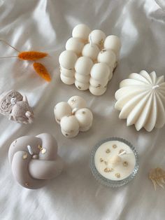 several different types of soaps on a white sheet next to an orange and yellow feather