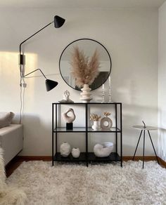 a living room filled with furniture and a mirror on top of a shelf next to a couch