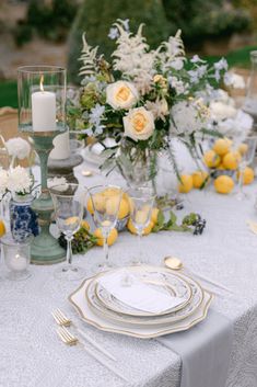 the table is set with yellow and white flowers