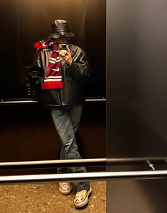 a man taking a selfie in front of an elevator door with his cell phone