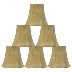 six beige lampshades stacked up in the shape of a pyramid on a white background