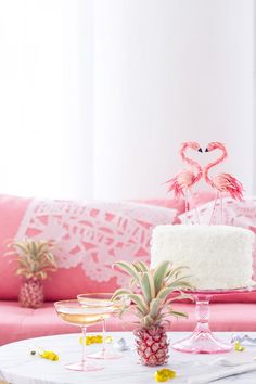 a table topped with a cake and two pineapples