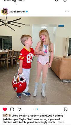 two children dressed up as football players and one is holding a ball in her hand