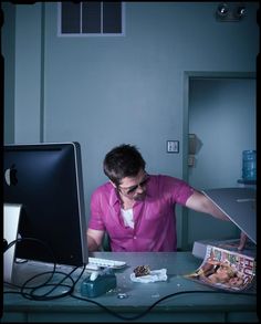 a man sitting at a desk in front of a computer monitor with the caption'create a composition that tells a marrive story, like dan winters photography featuring brad pitt