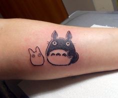 a person with a totoro tattoo on their arm