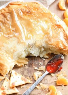 a piece of pie with a spoon in it on a cutting board next to oranges