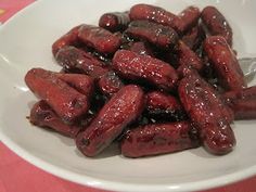 a white bowl filled with lots of red food on top of a pink table cloth