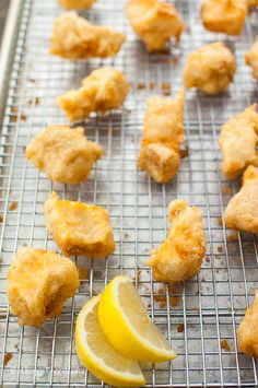 some food that is sitting on a rack with lemon wedges and a slice of lemon