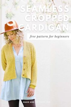 a woman standing in front of a white wall wearing a yellow knitted cardigan