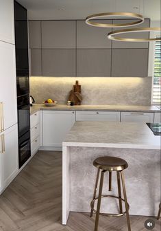 a modern kitchen with an island counter and stools in front of the bar area