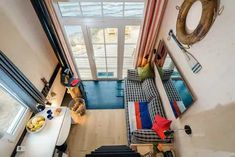 an aerial view of a living room and kitchen from the top floor, looking down