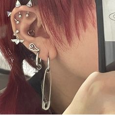 a woman with red hair and piercings on her ear