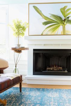 a living room with a couch and a painting on the wall above it's fireplace