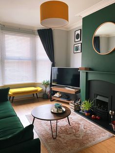 a living room filled with furniture and a flat screen tv on top of a wooden table