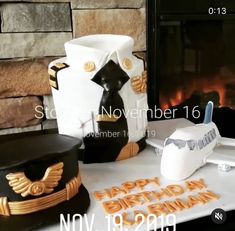 a table topped with cakes and hats next to a fireplace