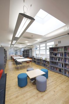 an empty library with tables, chairs and bookshelves