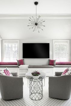 a living room filled with furniture and a flat screen tv mounted to the side of a wall