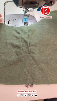 someone is using a sewing machine to sew the bottom part of a green shirt