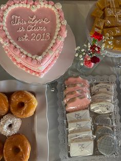 a table topped with lots of cakes and donuts