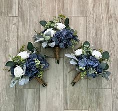 three bouquets of blue and white flowers are arranged on the floor in this photo