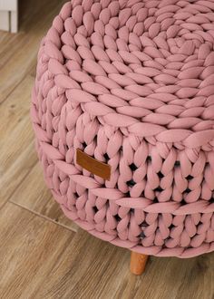 a pink knitted stool with wooden legs