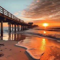 the sun is setting over the ocean with a pier in the foreground and waves crashing on the beach