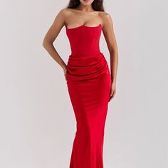 a woman in a red dress posing for the camera with her hands on her hips