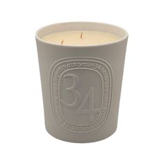 a white candle with the number 34 on it's front and side, sitting next to a white background