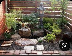 a small garden with rocks, plants and a lantern in the center is shown here